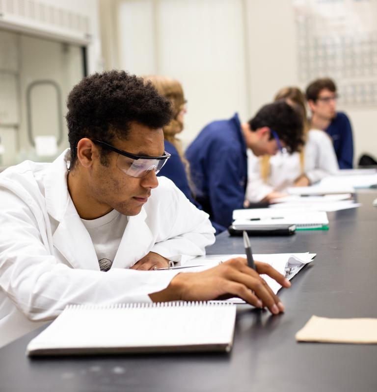 Student in a chemistry class with a textbook they are reading