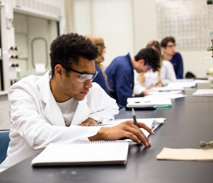 Student in a chemistry class with a textbook they are reading